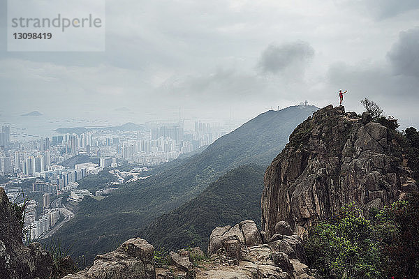 Fernansicht eines Mannes  der bei nebligem Wetter im Stadtbild auf einem Berg steht