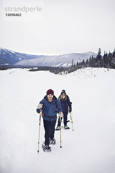 Porträt einer Frau mit ihrem erwachsenen Sohn beim Schneeschuhlaufen