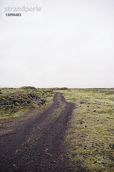 Unbefestigte Straße auf Feld gegen Himmel