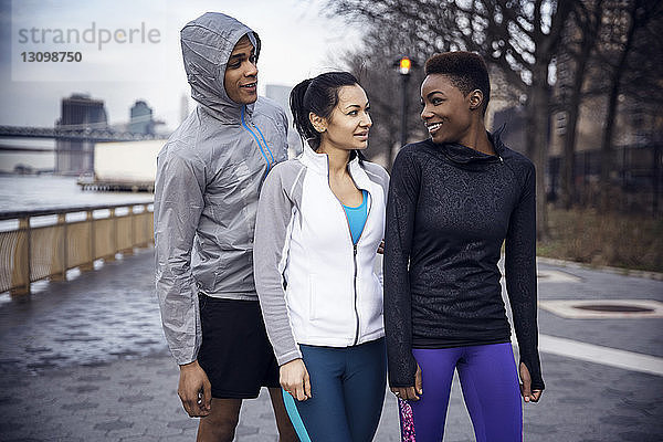 Glückliche multiethnische Athleten im Gespräch auf dem Fußweg