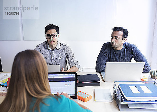 Geschäftsleute mit Laptop-Computern während einer Sitzung im Sitzungssaal