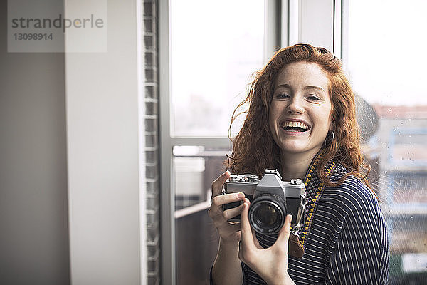 Porträt einer glücklichen Frau mit Kamera