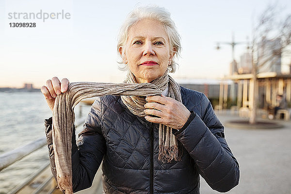 Porträt einer selbstbewussten älteren Frau mit Schalldämpfer auf der Promenade bei Sonnenuntergang
