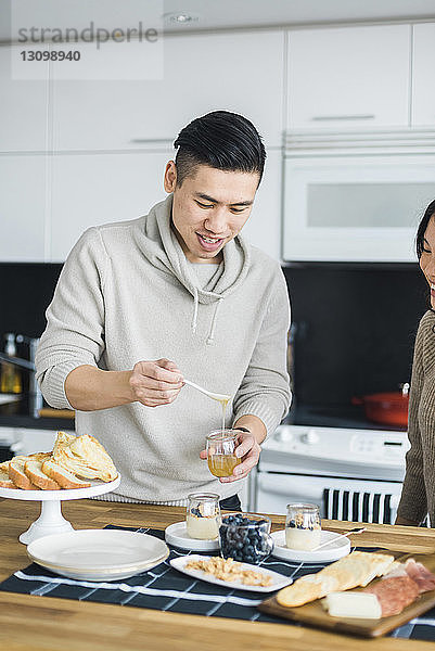 Mann mit Freundin bereitet das Frühstück in der Küche vor