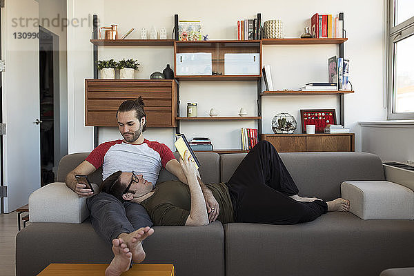 Homosexuelles Paar entspannt sich zu Hause auf dem Sofa