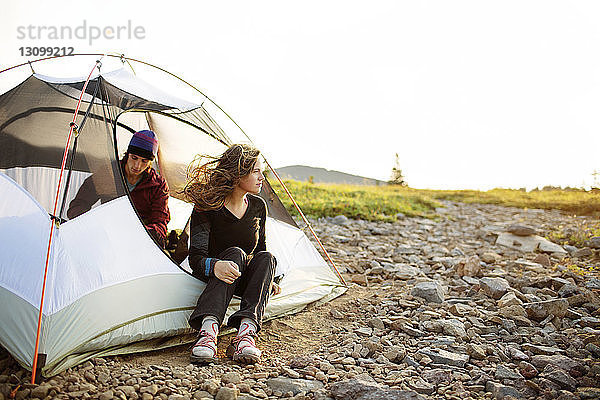 Glückliches Paar entspannt sich im Zelt bei klarem Himmel