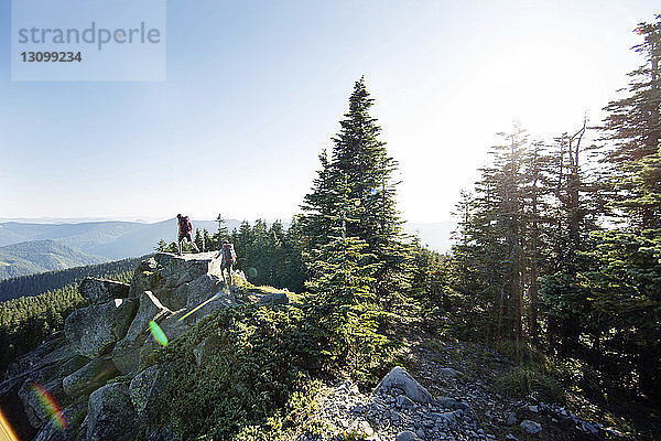 Hochwinkelansicht eines auf dem Berg wandernden Paares bei klarem Himmel