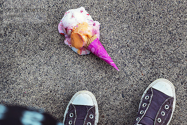 Hochwinkelansicht von Eiscreme  die auf einen Fußweg gefallen ist