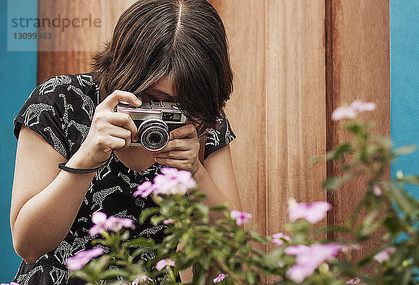 Frau fotografiert Blumen durch die Kamera