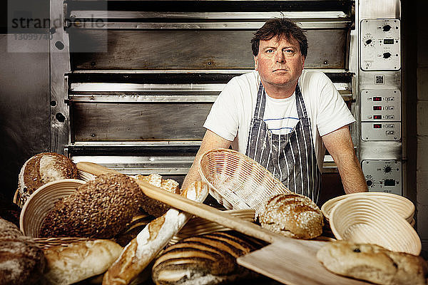 Porträt eines selbstbewussten männlichen Bäckers  der in einer Großküche steht
