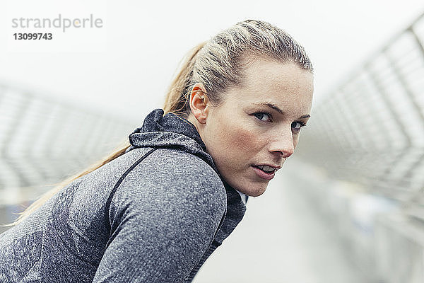 Porträt einer müden Sportlerin auf der Brücke