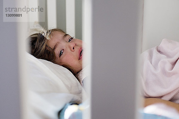 Porträt eines weinenden Mädchens  das zu Hause im Gitterbett liegt