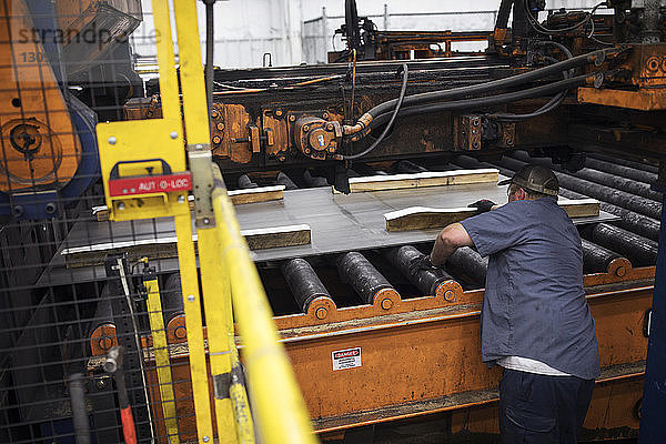 Hochwinkelansicht eines Arbeiters  der in einer Fabrik der Metall-Stahlindustrie arbeitet