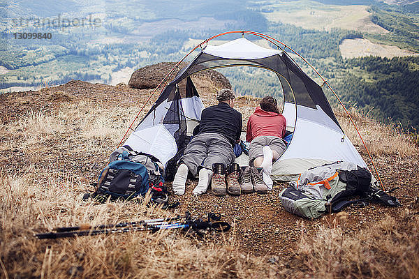 Paar im Zelt auf Berg liegend