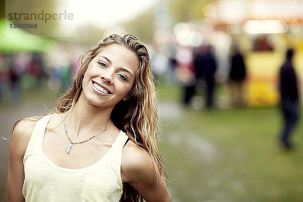 Porträt einer glücklichen jungen Frau  die im Vergnügungspark steht