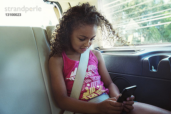 Mädchen benutzt Smartphone auf Reisen im Auto