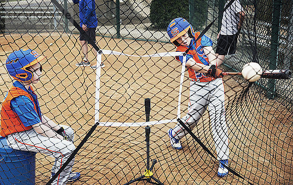 Jungen spielen Baseball auf dem Spielfeld