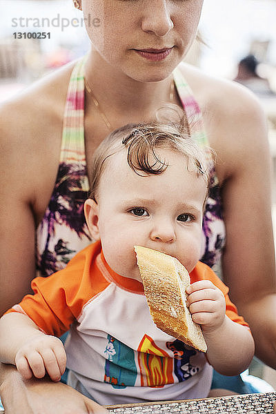 Mutter trägt Tochter mit Brot