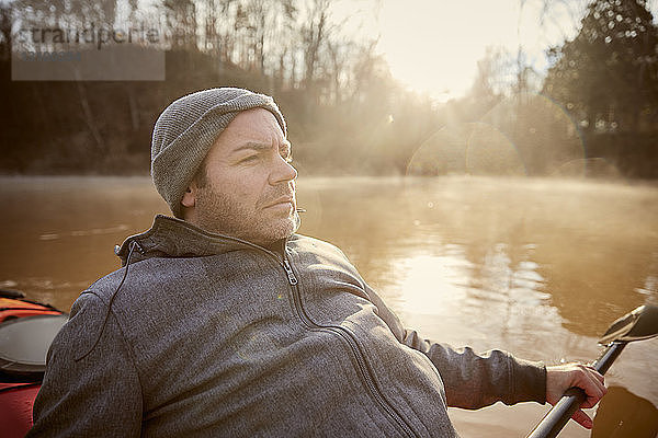 Mann schaut beim Kajakfahren auf dem Chattahoochee-Fluss gegen den Himmel