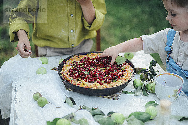 Brüder essen süßen Kuchen im Hof