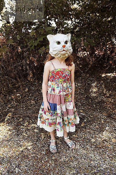 Junges Mädchen mit Katzenmaske im Freien