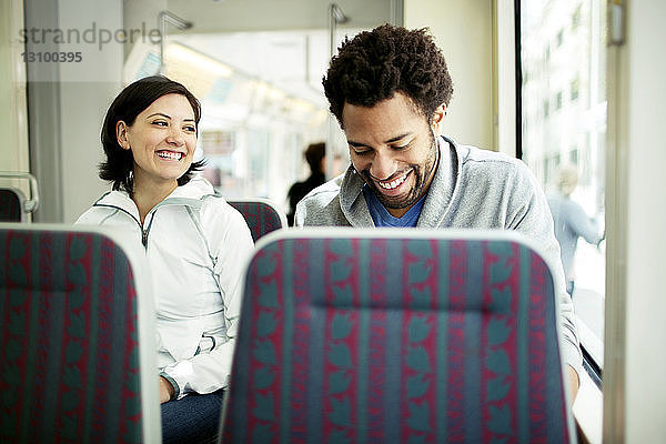 Glückliches multiethnisches Paar reist im Bus