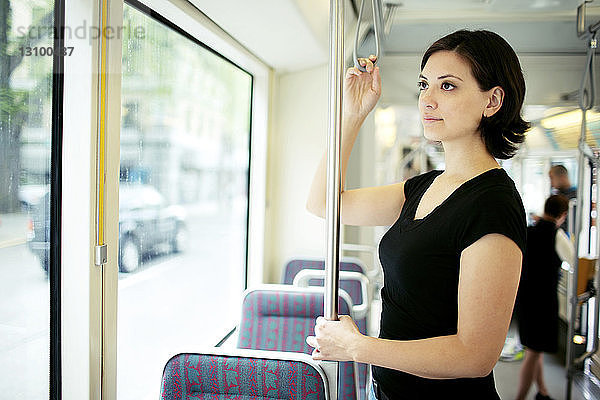 Nachdenkliche Frau steht im Bus