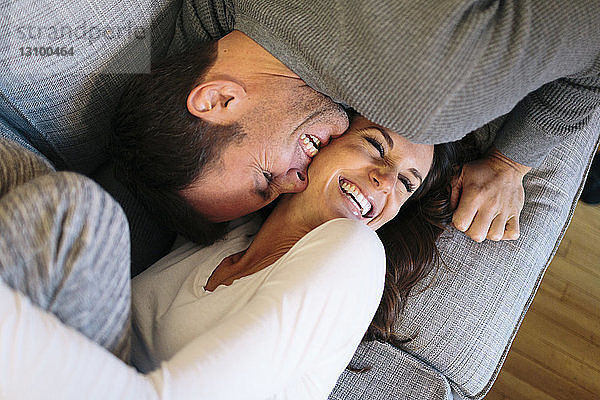 Draufsicht auf das glückliche Paar auf dem heimischen Sofa
