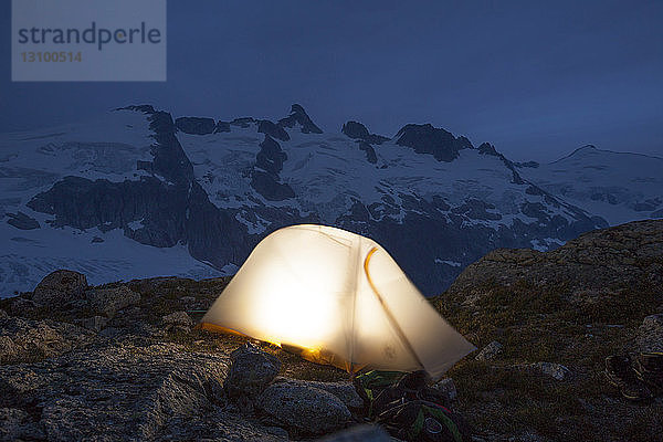 Hochwinkelansicht eines beleuchteten Zeltes auf einem Berg bei Nacht