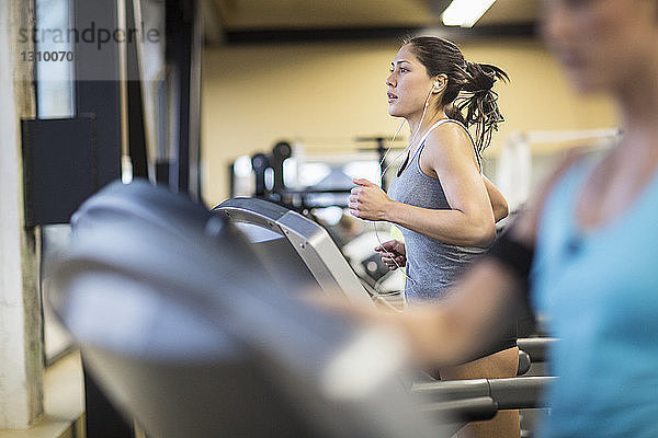 Frauen trainieren auf Laufbändern im Fitnessclub