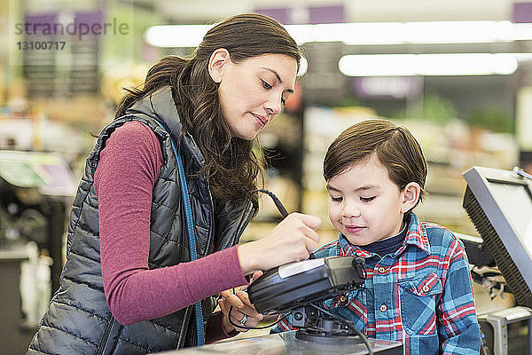 Mutter mit Sohn an der Kasse im Supermarkt