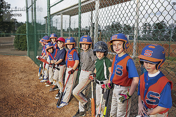 Baseball-Team steht am Kettengliedzaun auf dem Spielfeld