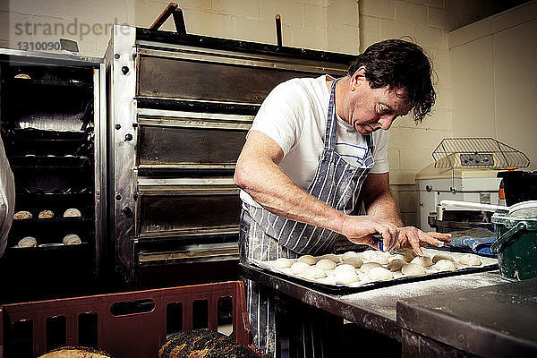 Männlicher Bäcker  der in einer Großküche arbeitet