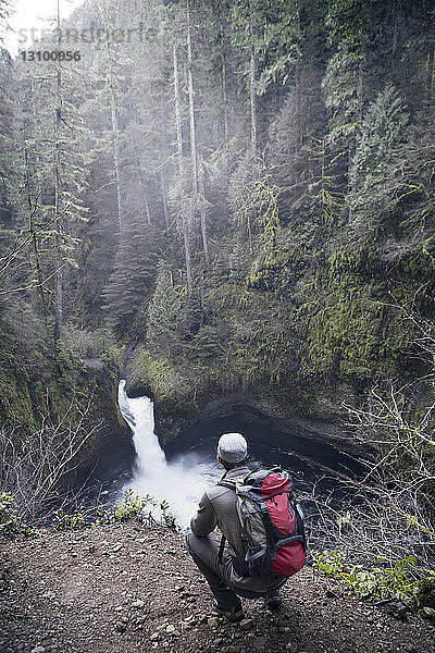 Blick des Menschen auf den Wasserfall im Wald