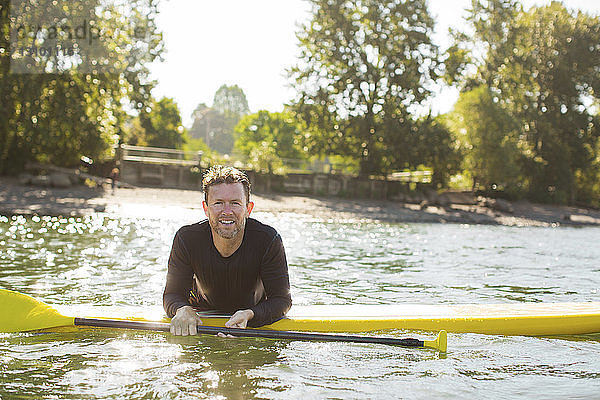 Porträt eines lächelnden Mannes beim Paddelbootfahren auf einem Fluss