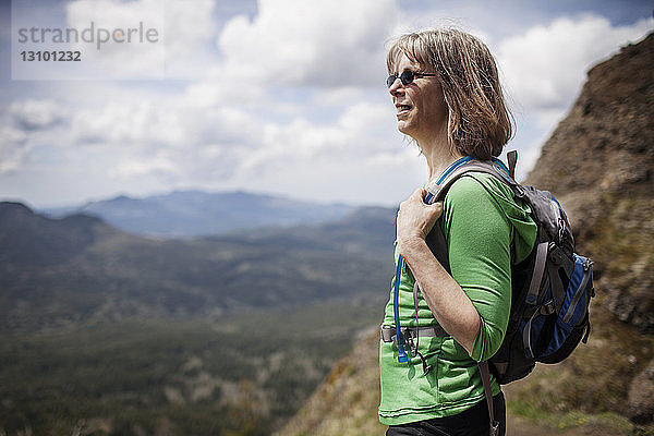 Frau trägt Rucksack  während sie auf Berg steht