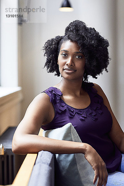 Porträt einer selbstbewussten Geschäftsfrau  die im Büro sitzt