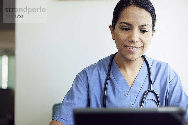 Lächelnde Ärztin mit Tablet-Computer im Krankenhaus