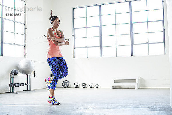 Sportlerin beim Training mit Springseil in der Turnhalle