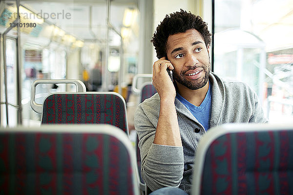 Mann benutzt Smartphone während einer Busreise