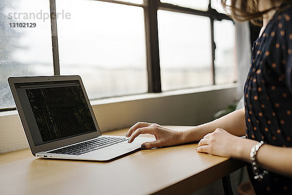 Frau mit Laptop auf Tisch im Café