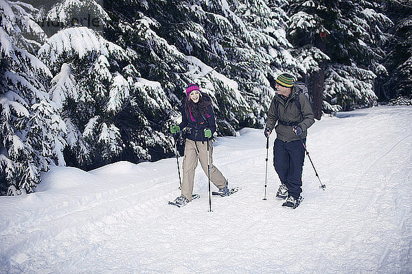 Paar Schneeschuhwandern im Wald