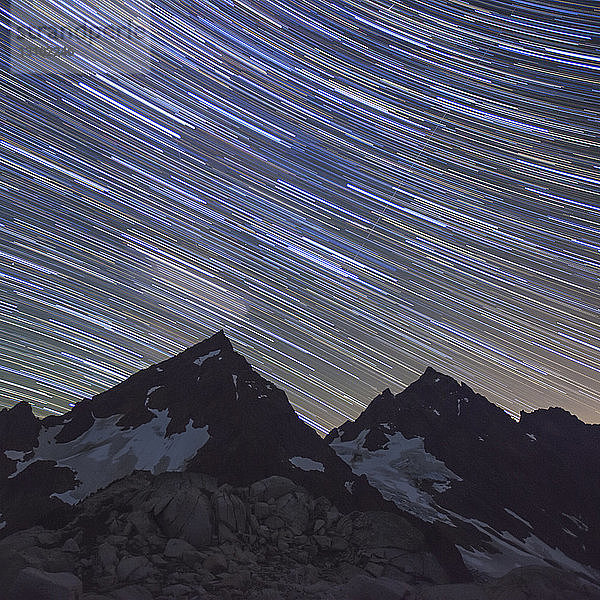 Niedrigwinkelansicht von Sternenpfaden über den Bergen bei Nacht