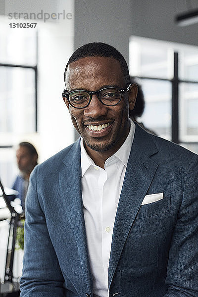 Porträt eines glücklichen Geschäftsmannes mit Brille im Büro