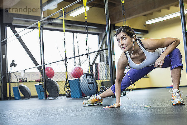 Selbstbewusste Frau  die beim Sport im Fitnessstudio Musik hört