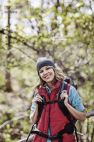 Porträt einer glücklichen Wanderin im Wald stehend