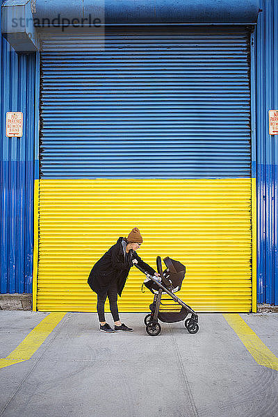 Seitenansicht einer Frau mit Kinderwagen auf der Straße