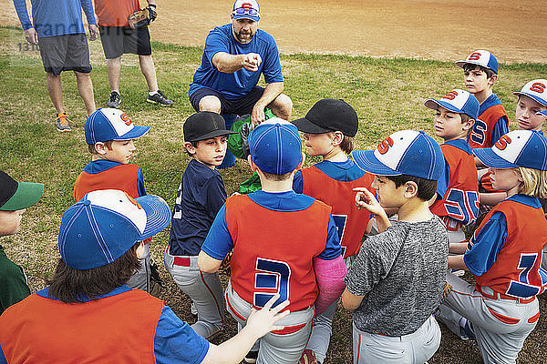 Baseball-Trainer instruiert Jungen auf dem Feld