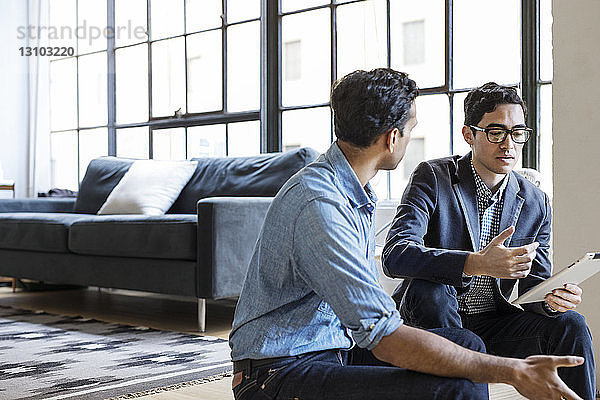 Geschäftsleute diskutieren über digitales Tablet im Büro