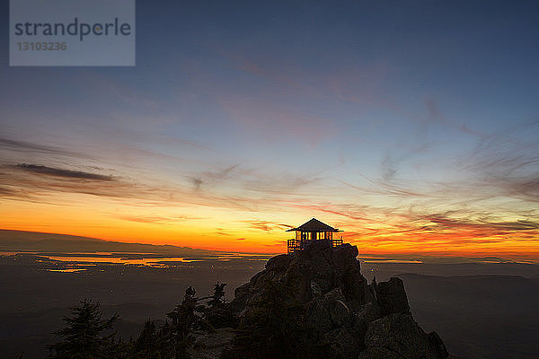 Silhouette eines Feuerwachturms auf Bergen gegen den Himmel bei Sonnenuntergang